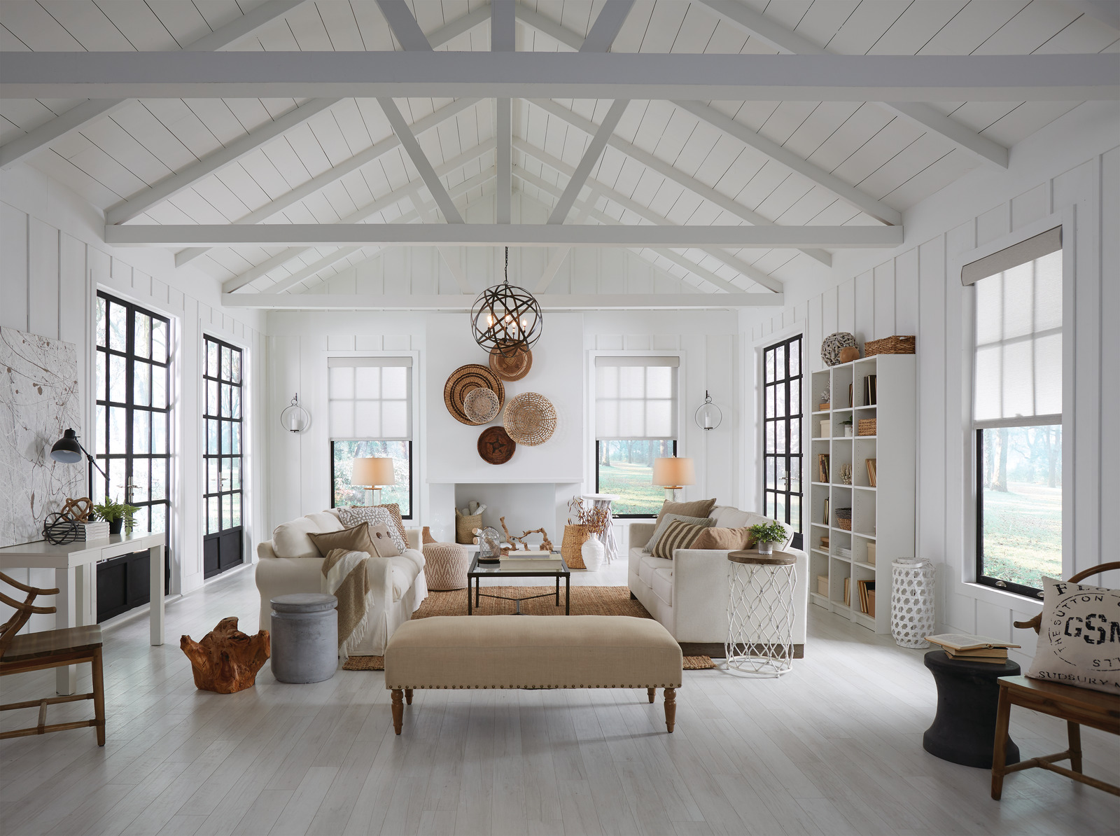A bright living room with roller shades fitted to tall windows