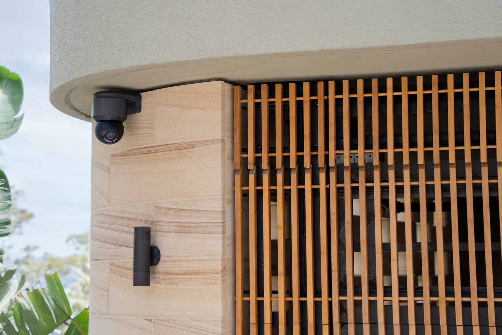 A black Luma camera mounted beneath the overhang of a wood-clad entrance